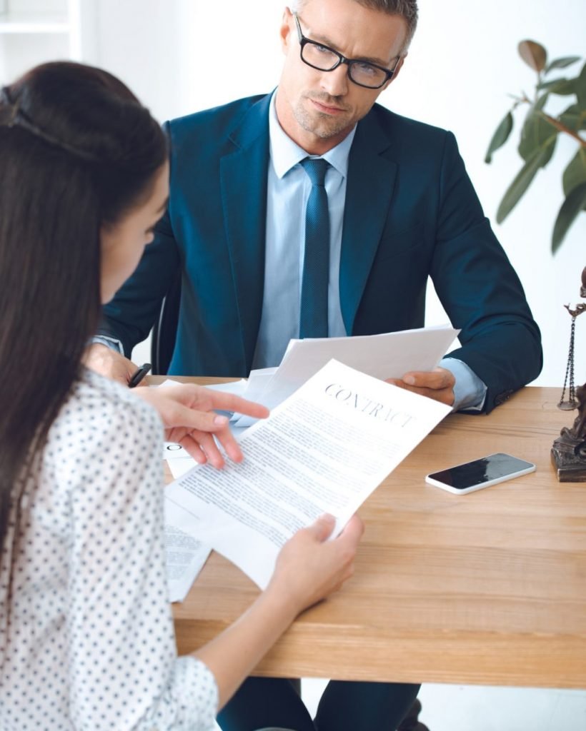 male lawyer looking at client reading contract